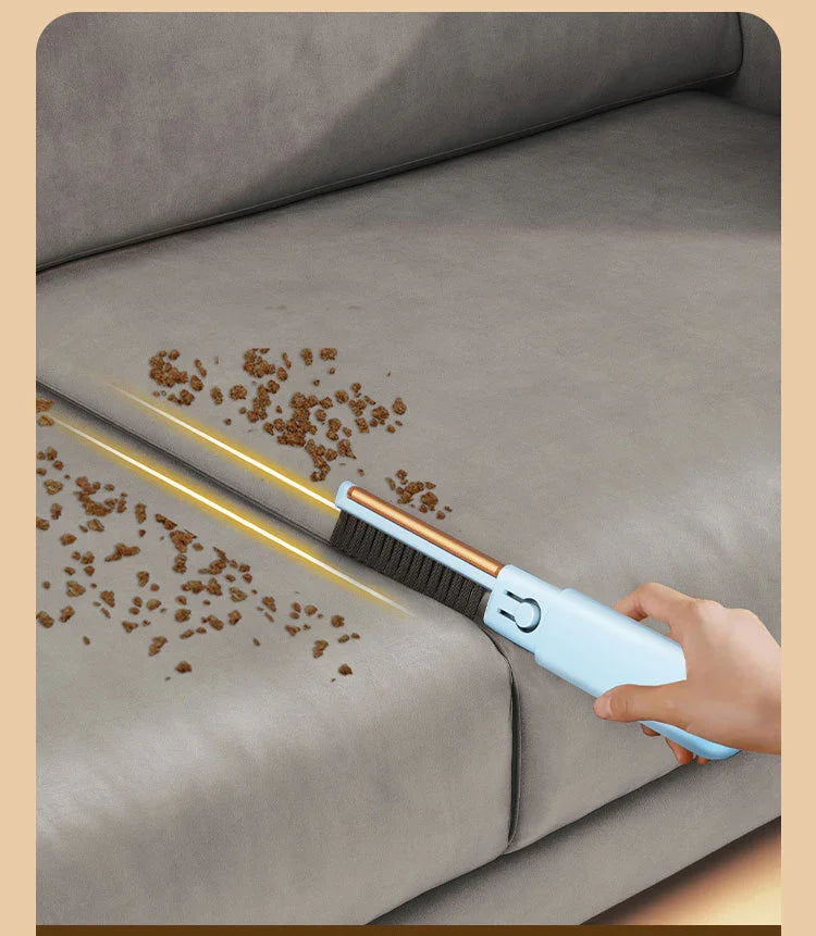 Hand using pet hair remover brush on gray sofa with crumbs, ideal for fur-free living