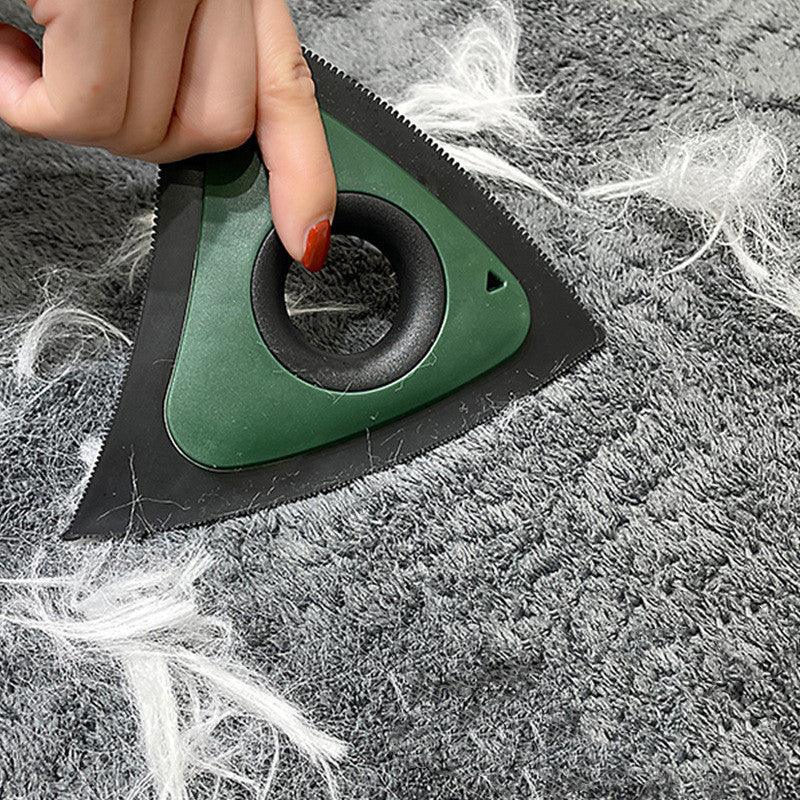 Green pet hair remover tool scraping white fur from gray carpet, ideal for fur-free living